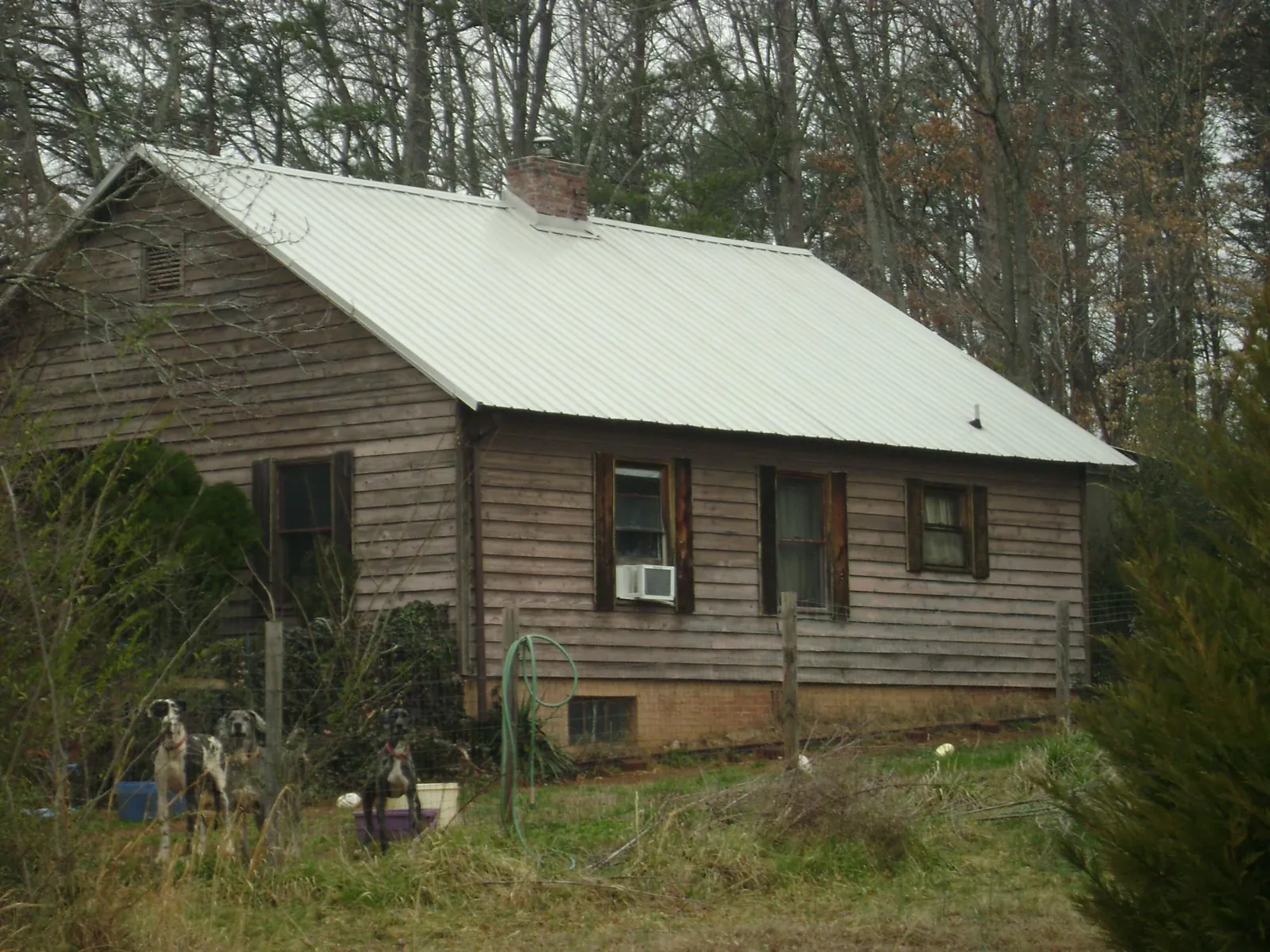 White metal roof on an old wood sided farmhouse, from a Asphalt Shingle Roof Repair job in Convent